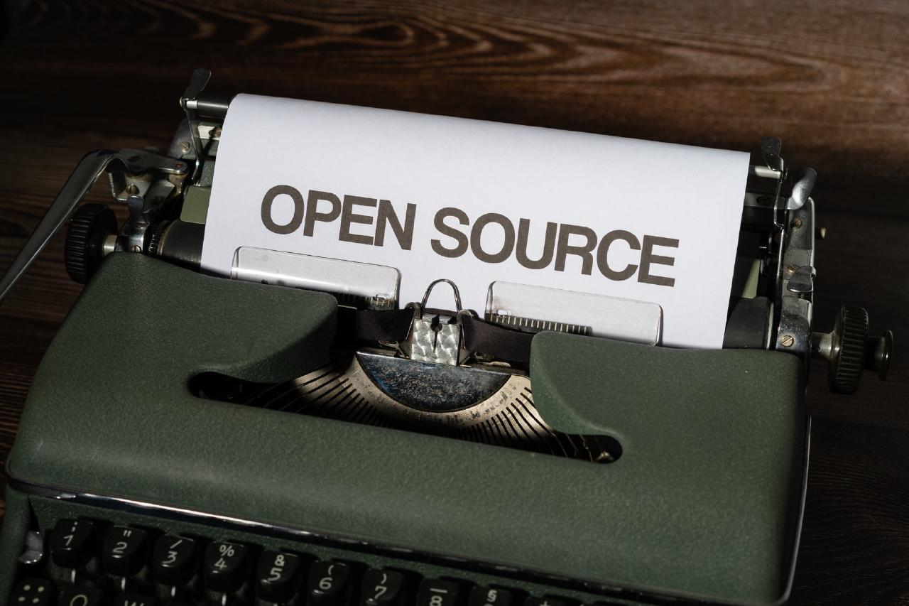 Photo of a type writer with the phrase 'open source' written on the page